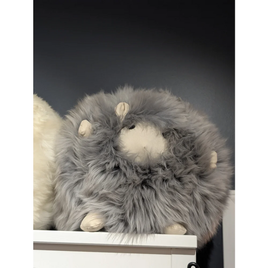 Cute plush sheepskin cushion with gray fur and white face