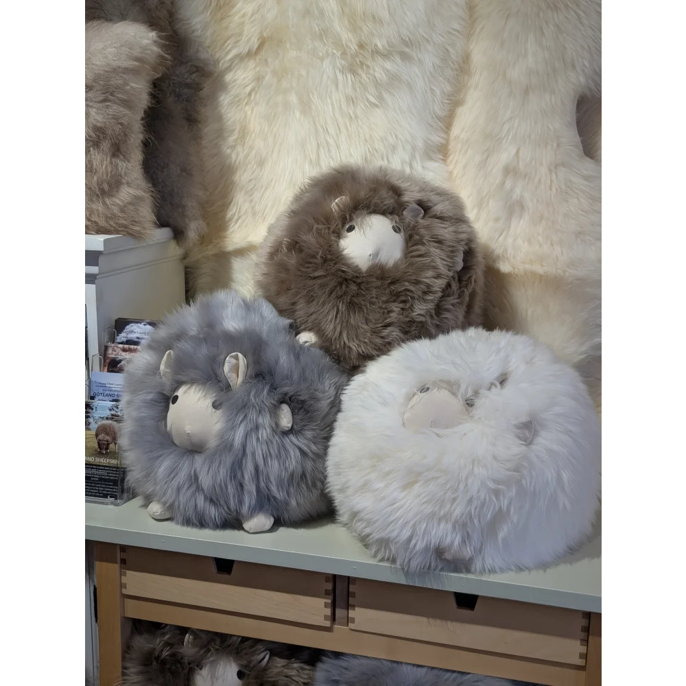 Cute fluffy gray white sheepskin cushion like a plush lamb