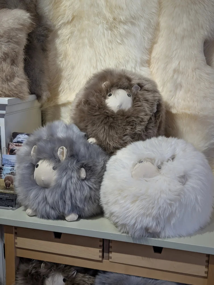 Cute fluffy gray white sheepskin cushion like a plush lamb