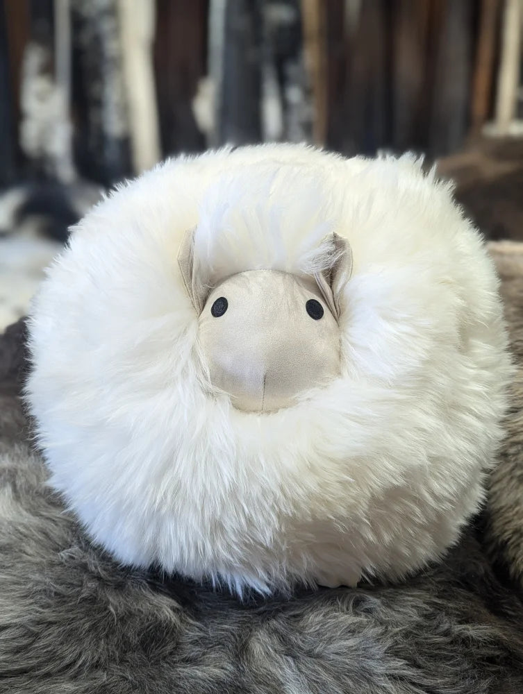Fluffy white rotund sheep cushion made of soft merino sheepskin with simple black button eyes restocked mid october