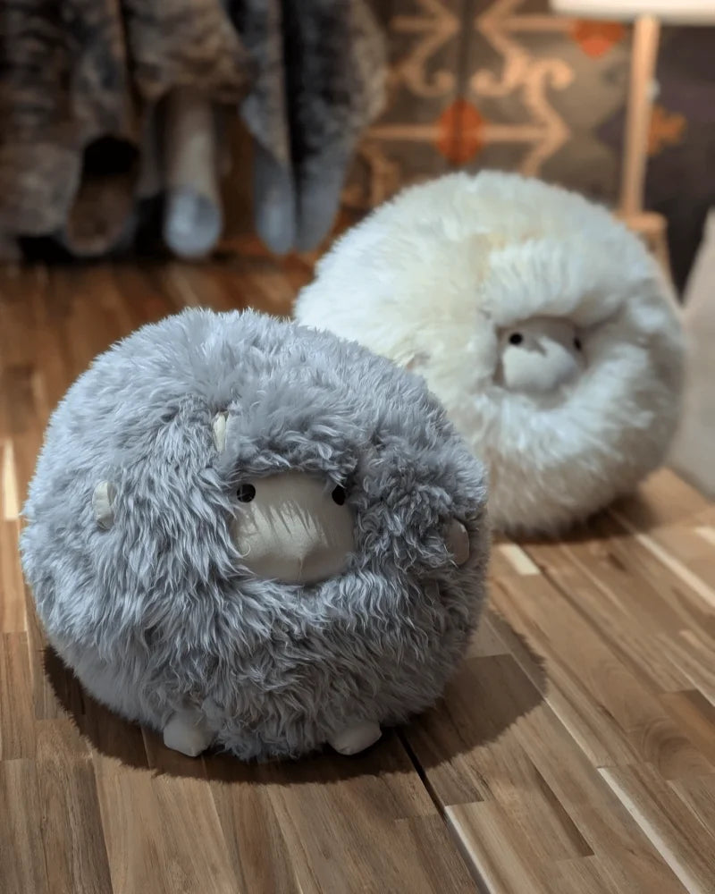 Soft plush gray rotund sheep cushion made from fluffy merino sheepskin with embroidered facial features