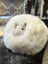 A plush round white rotund sheep cushion made of soft merino sheepskin with a cute alpaca face perfect for cozy decor