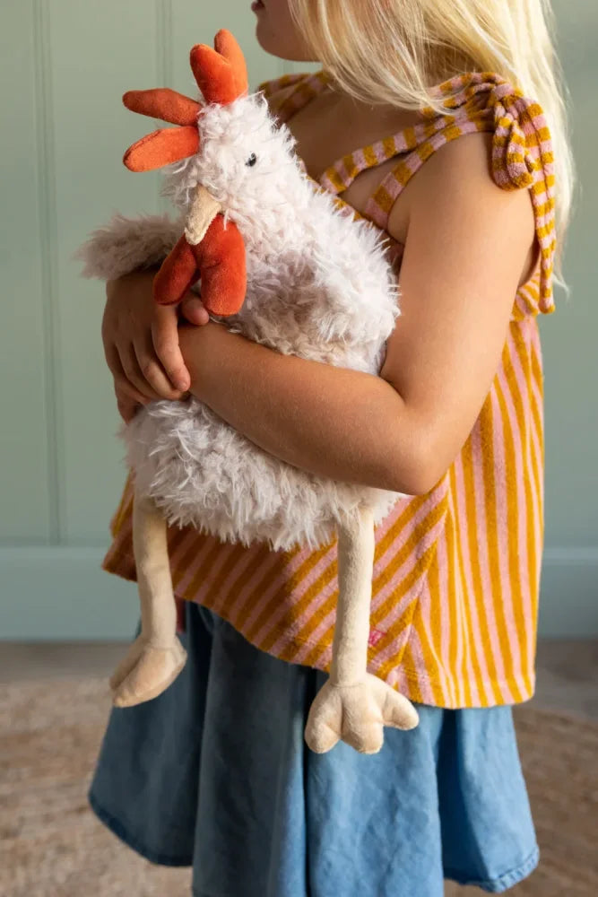 A plush white chicken toy named roy the rooster with orange comb and wattle made of soft textured fabric