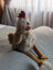 A plush chicken toy named rupert the rooster with a white and gray striped body by nana huchy