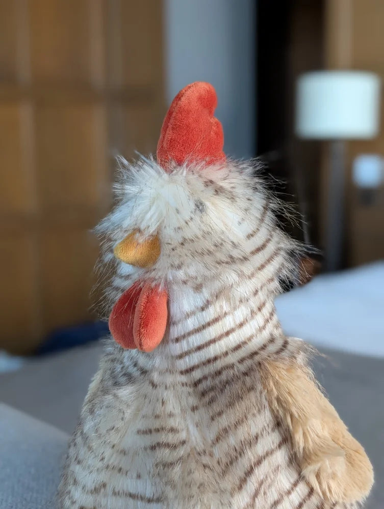 A plush toy chicken named rupert the rooster with fluffy white and brown stripes by nana huchy