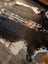 A beautiful extra large cowhide rug in salt and pepper brown with natural speckles laid on a wooden floor