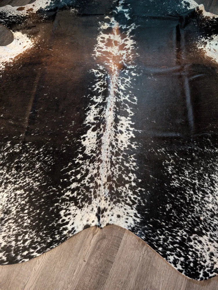 Salt and pepper brown large cowhide rug with black and white spots and natural irregular edges for beautiful rugs