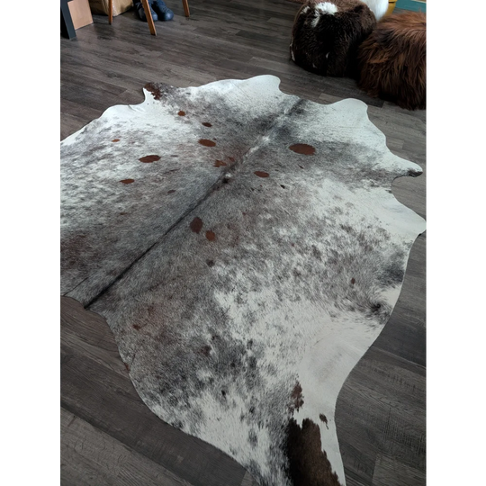 A gorgeous extra large natural cowhide rug in white gray and brown spotted saltpepbrn 141 pattern measuring 88 by 75 inches