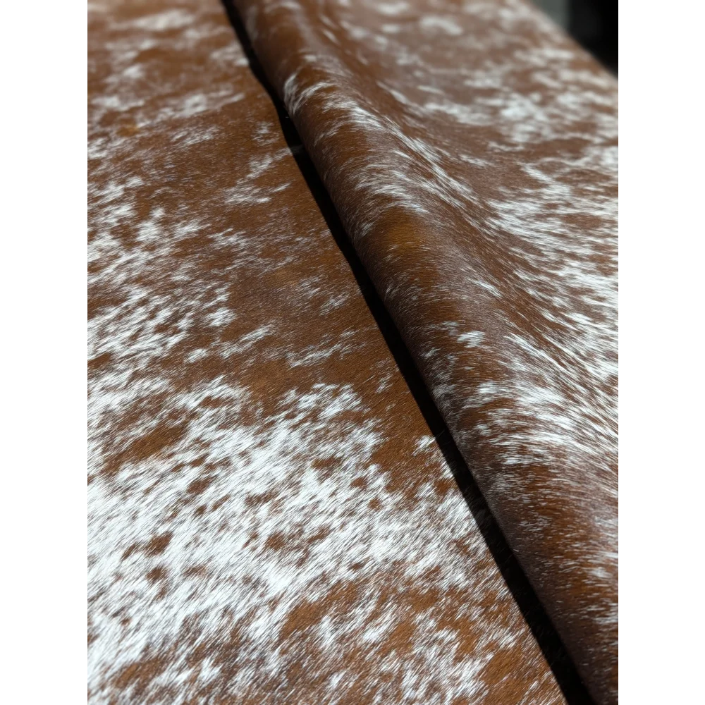 Extra large brown and white speckled cowhide rug with silver belt buckle