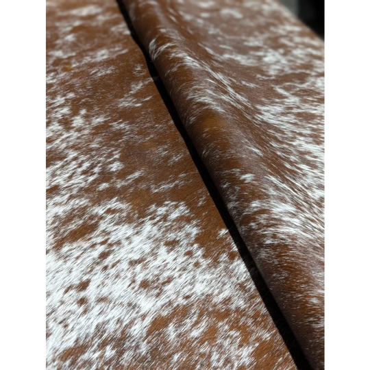 Extra large brown and white speckled cowhide rug with silver belt buckle