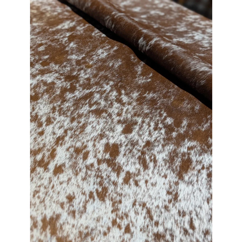 Brown and white speckled cowhide wallet chain on extra large cowhide rug