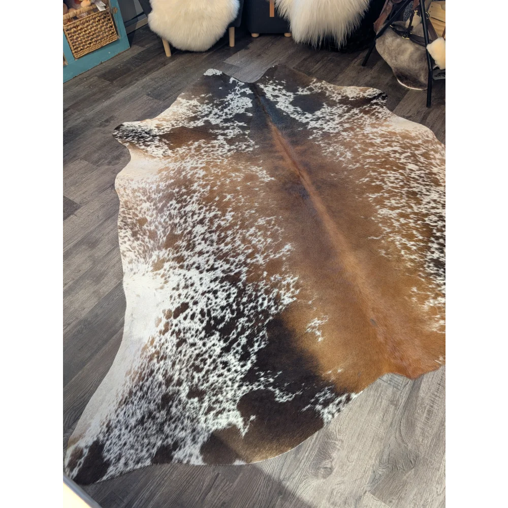 A beautiful extra large brown and white speckled cowhide rug saltpepbrn#189 on dark wood floor perfect large cowhide