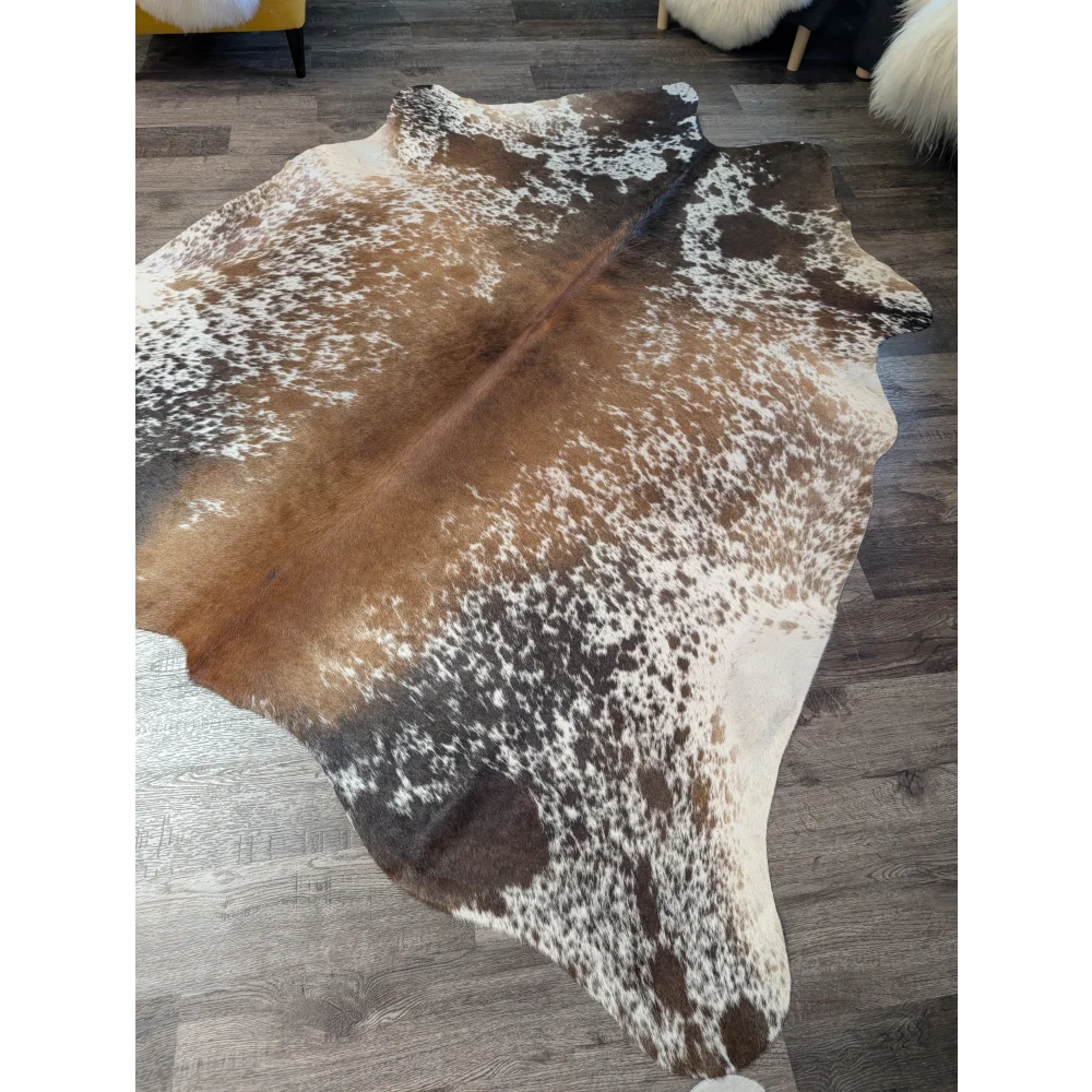 A beautiful extra large cowhide rug saltpepbrn189 with natural brown and white spots and a textured irregular shape