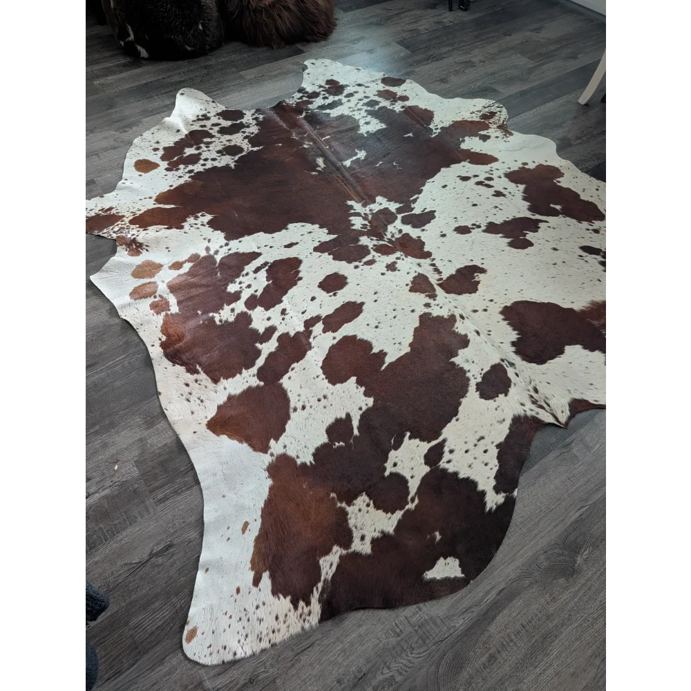 Beautiful extra large cowhide rug in brown and white with natural irregular patches perfect for large cowhide decor