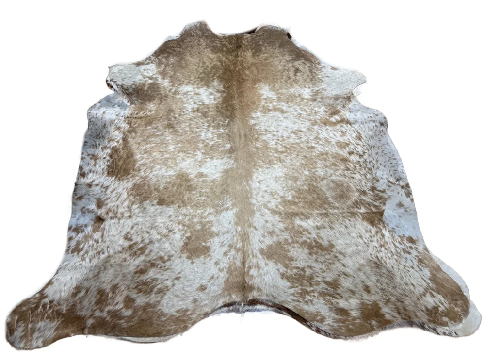 A large cowhide rug with natural tan and white colors and unique characteristics adds rustic charm arriving soon