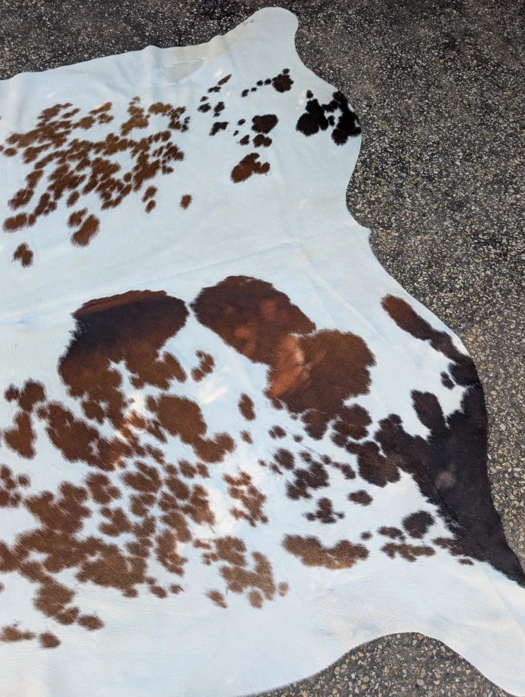 White cowhide rug with brown and black patches large cowhide rug by angus oliver with rustic charm arriving soon