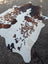Brown and white large cowhide rug with natural spotted pattern adding rustic charm from angus oliver arriving soon