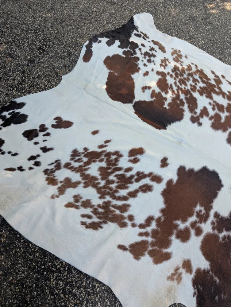 Brown and black spotted large cowhide rug with rustic charm and natural textured surface by angus oliver arriving soon