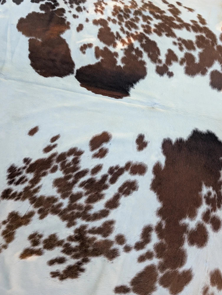 Brown and white large cowhide rug with rustic charm natural textured surface by angus oliver saltpepbrn358 arriving soon