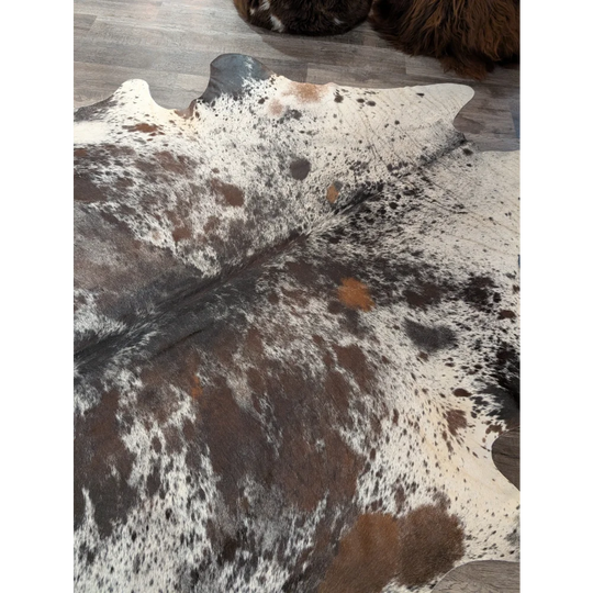 A natural extra large cowhide rug saltpepbrn38 with white brown and black spotted pattern measuring 96 by 83 inches