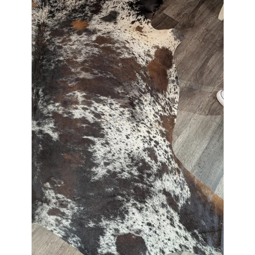 A gorgeous extra large cowhide rug with a black white and brown spotted pattern perfect for large spaces