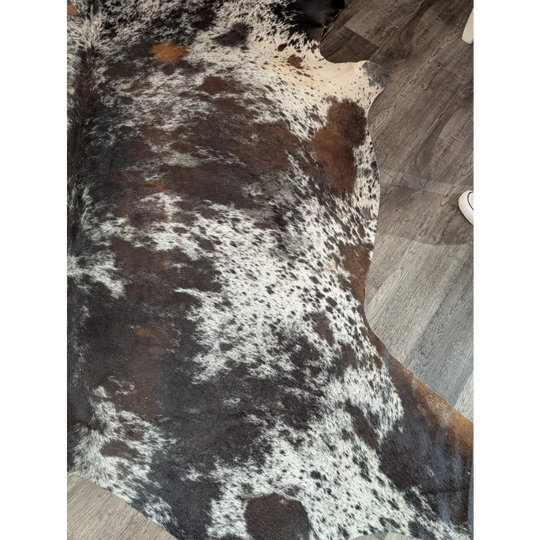 A gorgeous extra large cowhide rug with a black white and brown spotted pattern perfect for large spaces