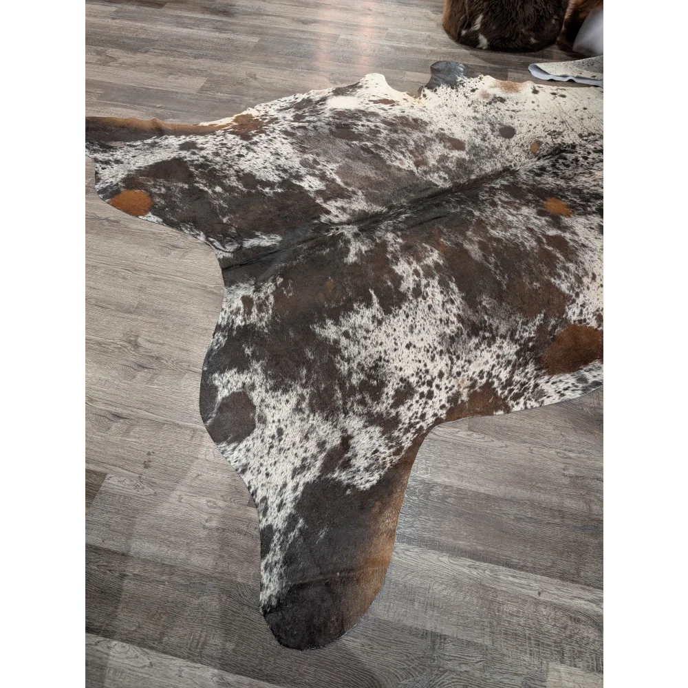 Extra large brown and white spotted cowhide rug with natural leather texture perfect as a large cowhide floor decor