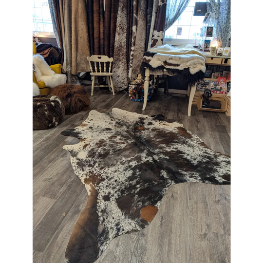 A natural brown and white speckled extra large cowhide rug saltpepbrn38 96 x 83 inches on the floor
