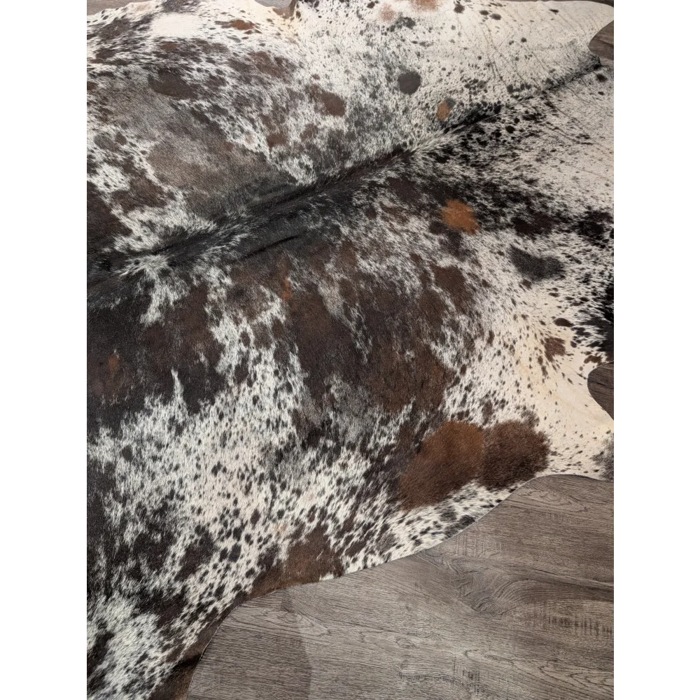 A gorgeous extra large cowhide rug in black white and brown spotted natural leather perfect for large cowhide decor