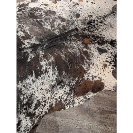 A gorgeous extra large cowhide rug in black white and brown spotted natural leather perfect for large cowhide decor