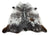 A large cowhide rug with a striking black and white spotted pattern and brown patches near edges from saltpepbrn506