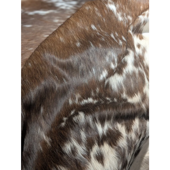 Extra large cowhide rug with brown white spotted fur and textured pattern