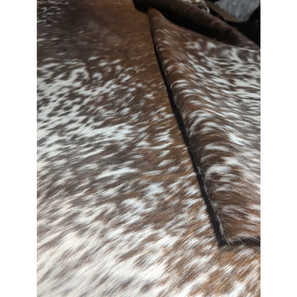 Extra large cowhide rug with brown white speckled pattern and leather edges