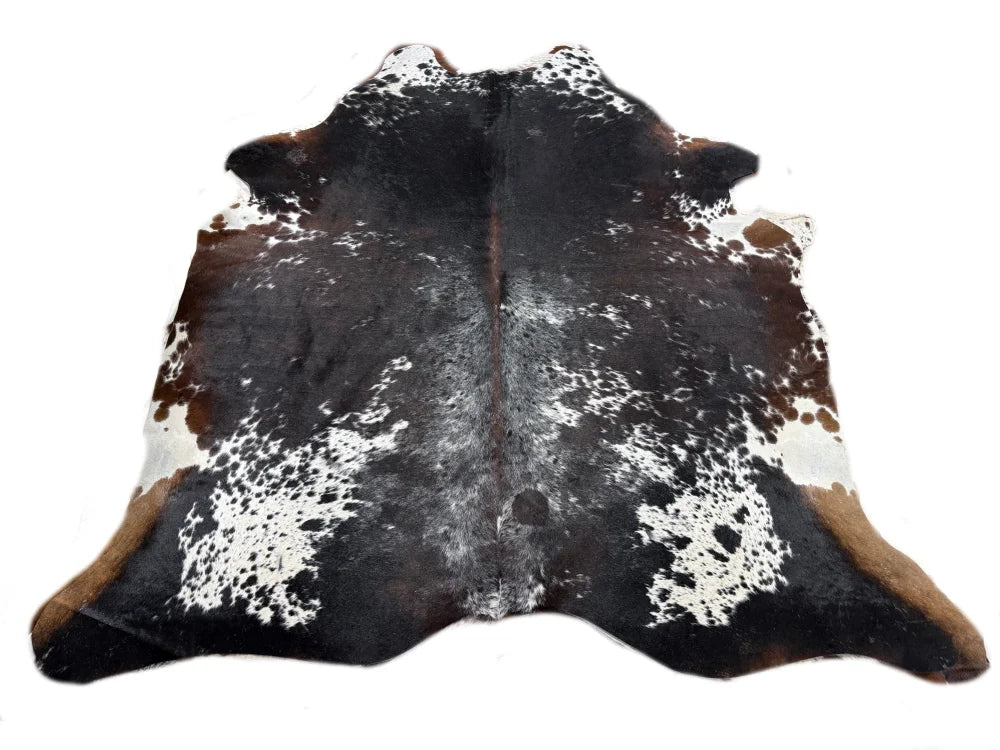 A natural extra large cowhide rug with rustic charm and unique black white and brown spotted pattern arriving soon