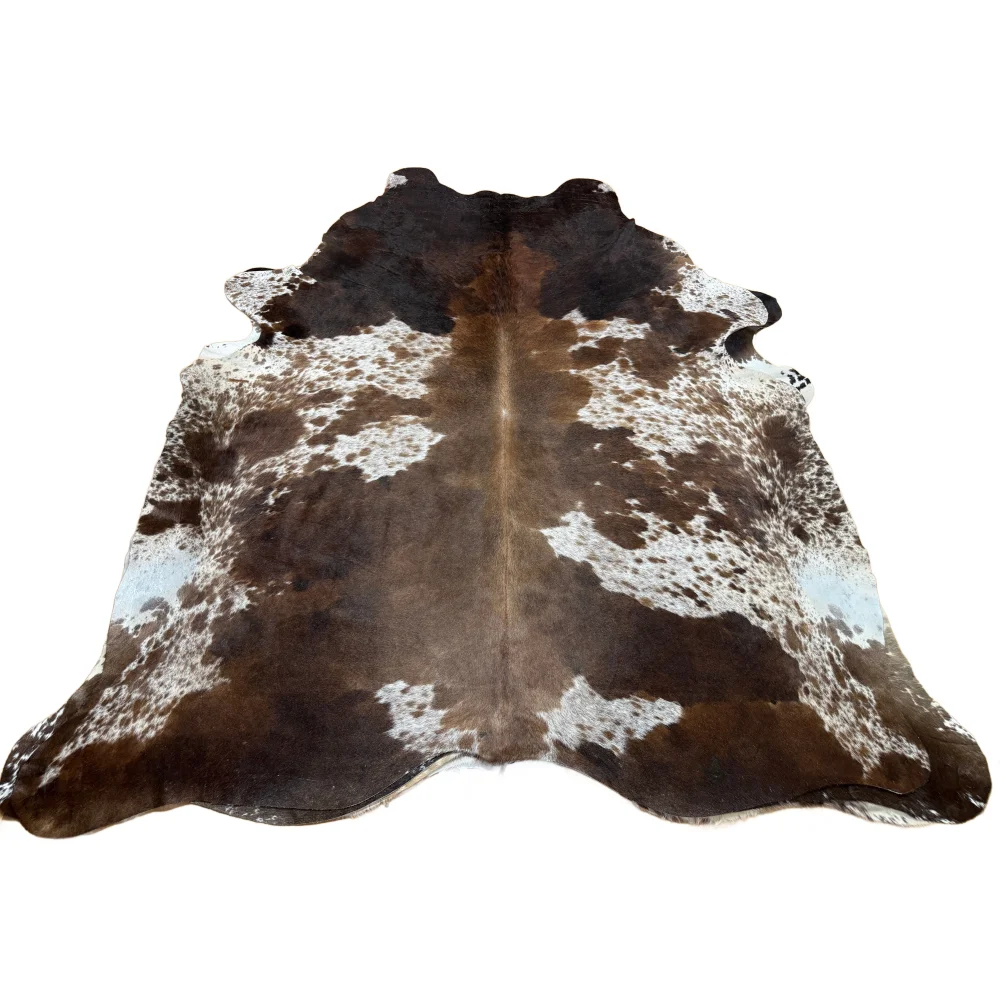 Extra large brown and white cowhide rug with natural fur texture offering rustic charm and unique characteristics arriving soon