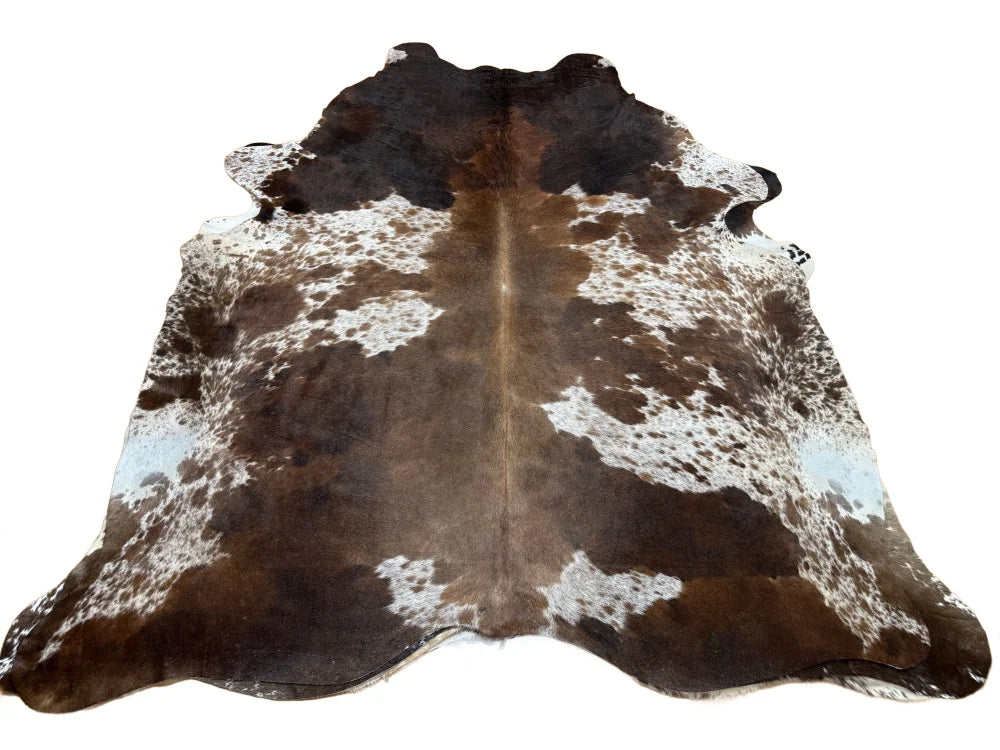 Extra large brown and white cowhide rug with natural fur texture offering rustic charm and unique characteristics arriving soon