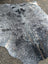 Large gray and black speckled cowhide rug with unique characteristics and natural irregular edge for rustic charm