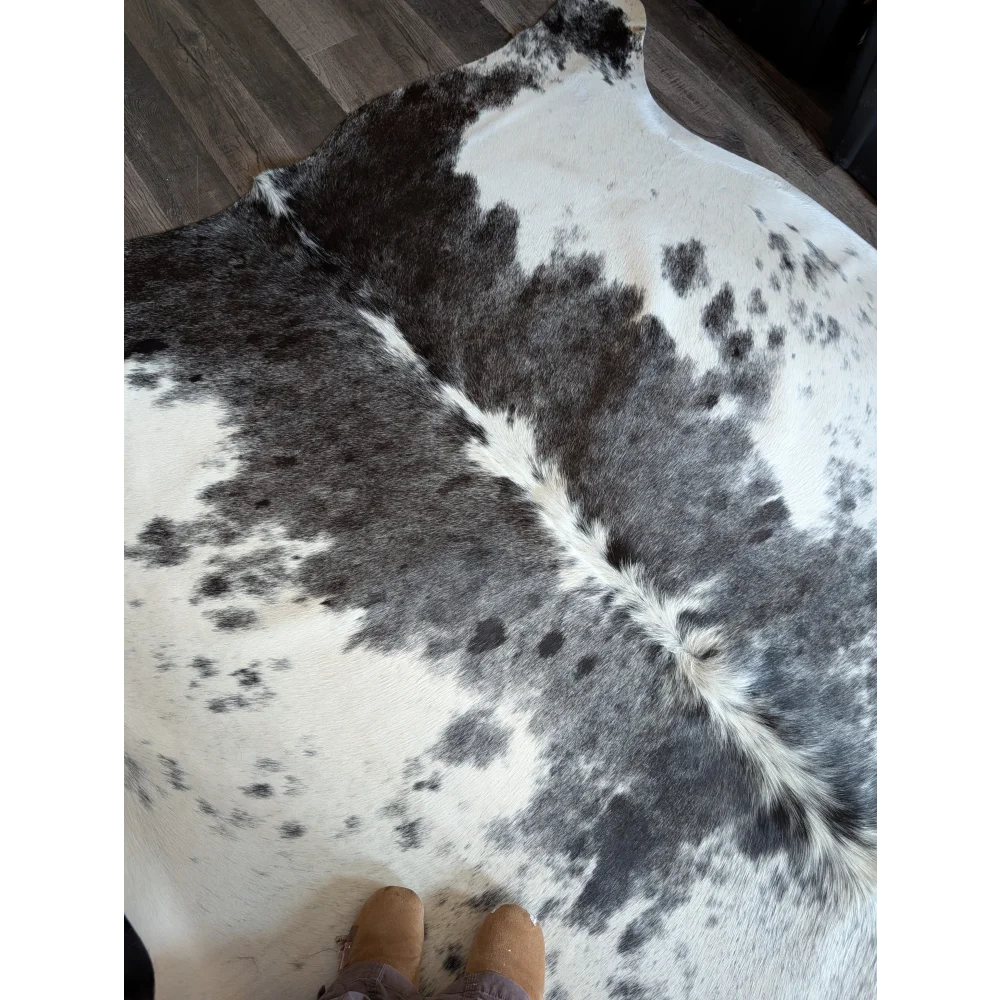 A beautiful large cowhide rug salty4 with a black and white spotted pattern adds rustic charm to any space