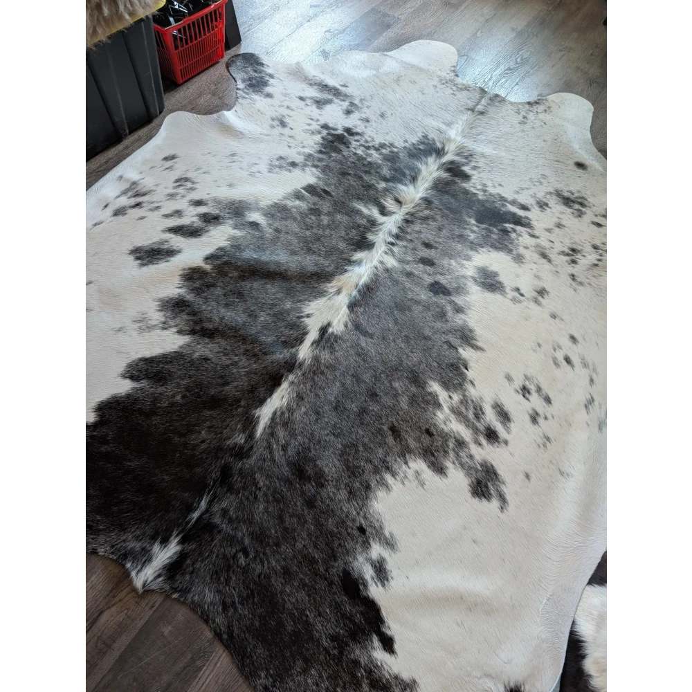 A large cowhide rug salty4 with a beautiful black and white pattern adds rustic charm to any room