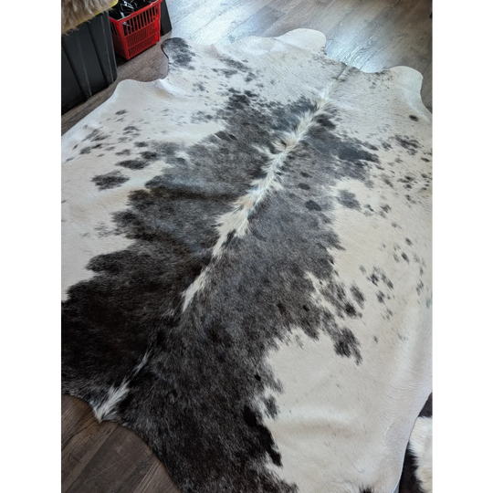 A large cowhide rug salty4 with a beautiful black and white pattern adds rustic charm to any room