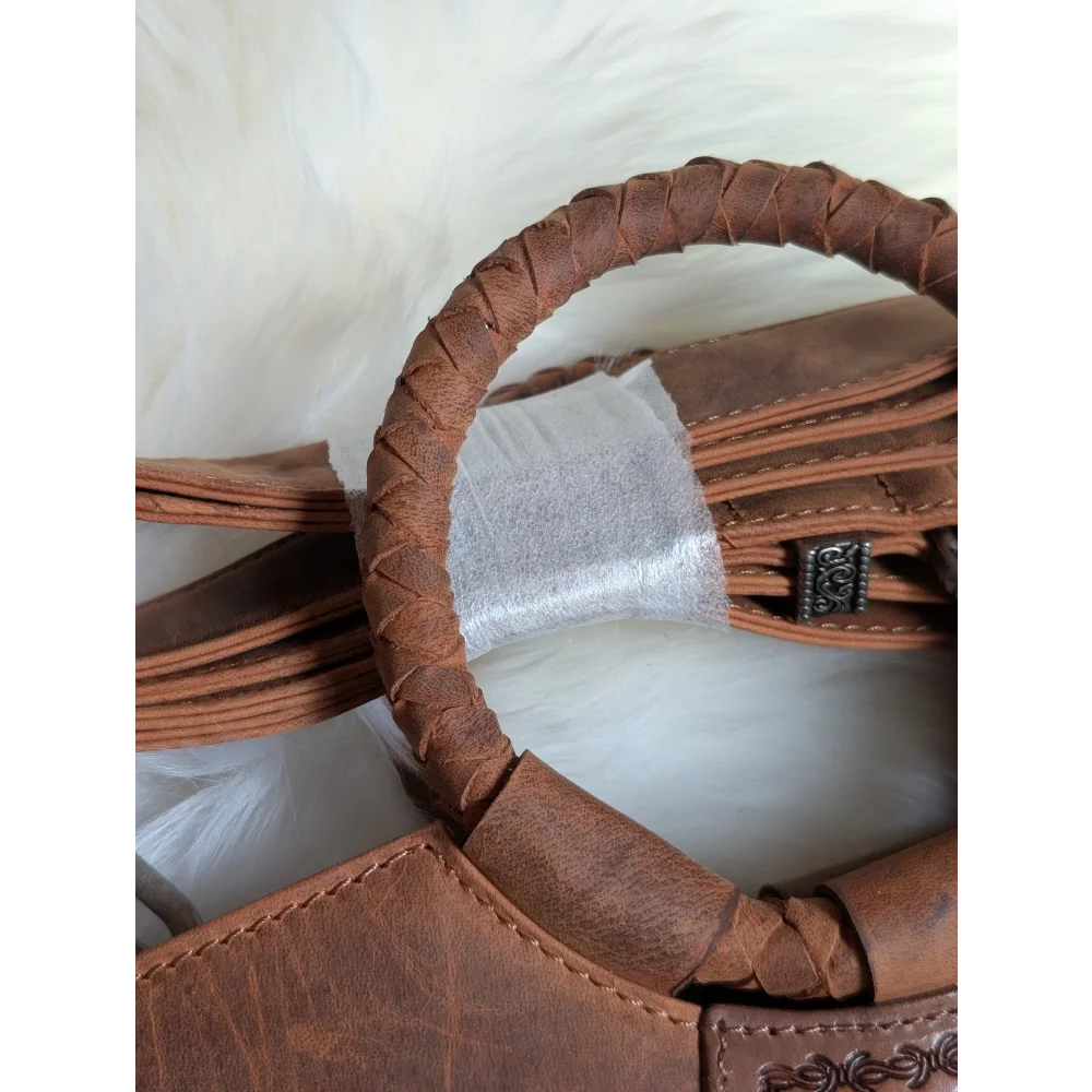 Brown leather sedona tassle bag with braided handle and decorative metal clasp in saddle brown