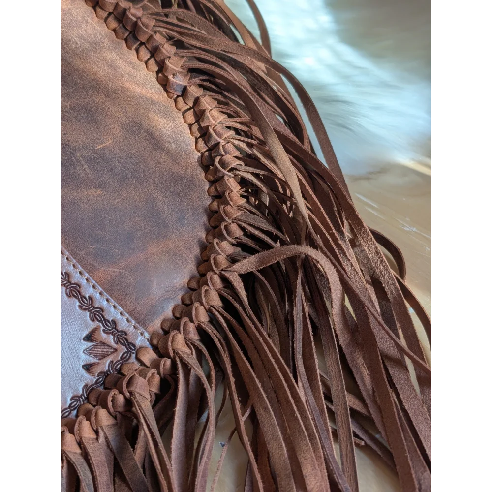 Brown leather tassle bag with braided detailing and embossed floral patterns in saddle brown sedona tassle bag