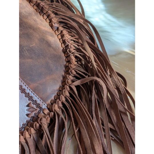 Brown leather tassle bag with braided detailing and embossed floral patterns in saddle brown sedona tassle bag