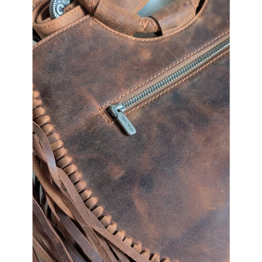 Brown leather sedona tassle bag in saddle brown with fringed detailing and silver-toned zipper pull