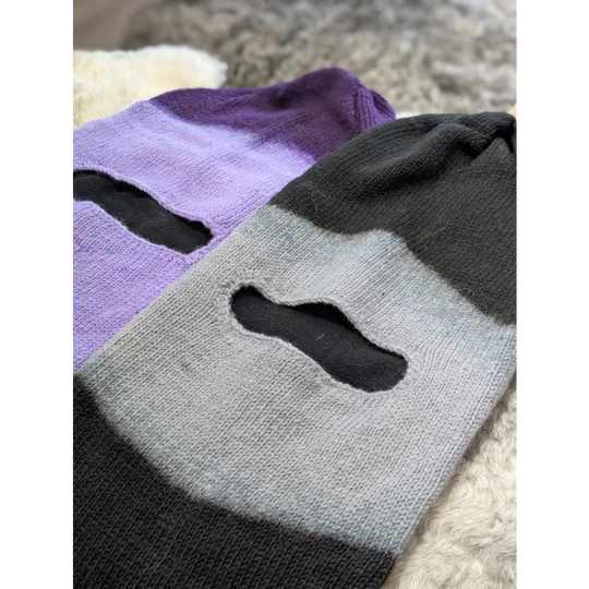 Two knitted moonstone dip dye slouch balaclavas with eye openings, purple and gray striped