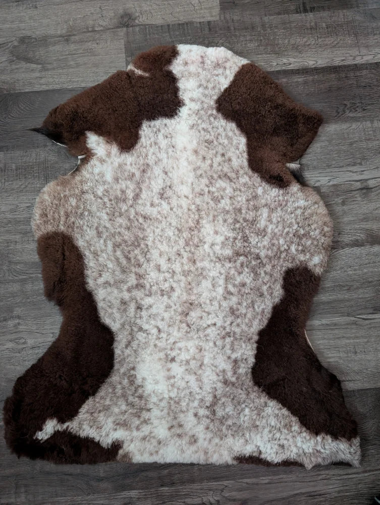 Brown and white tibet highland spotted sheepskin rug with natural fluffy texture perfect for cozy decor