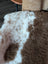 A plush 40 x 25 inch tibet highland spotted sheepskin rug with soft white and brown fur texture grade a quality