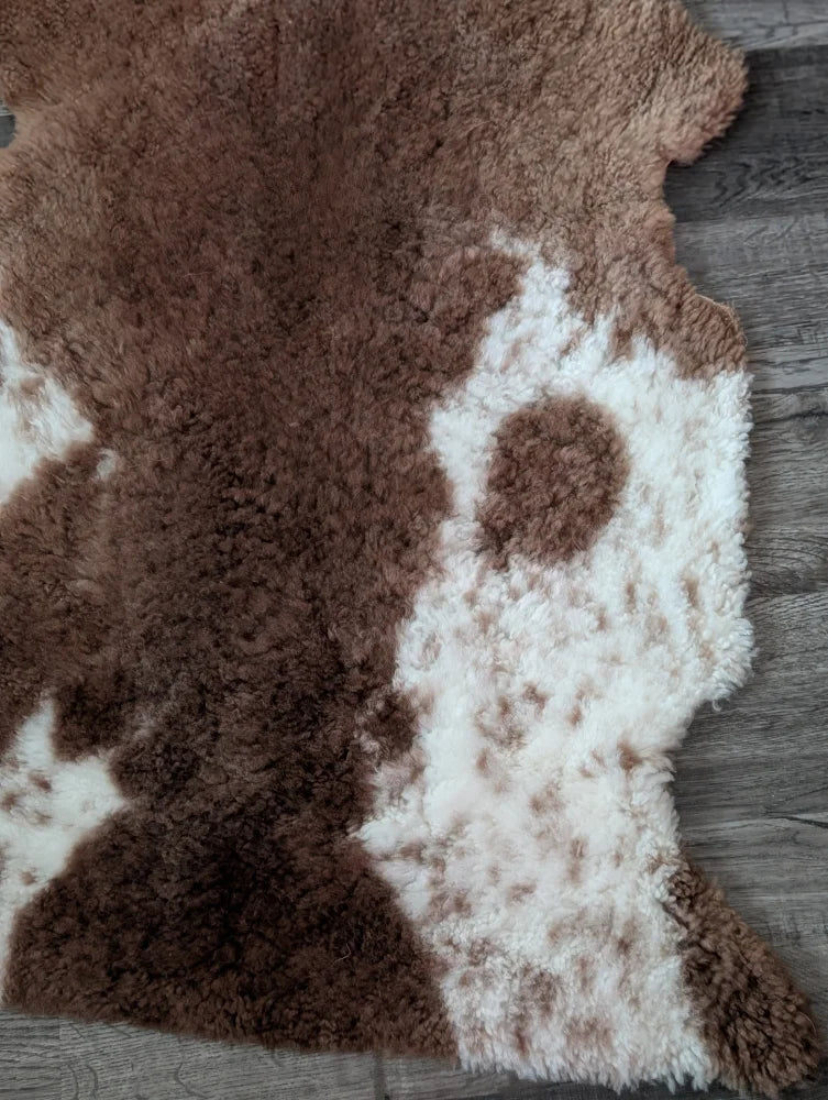 Brown and white tibet highland spotted sheepskin rug with a plush fluffy texture for cozy decor use