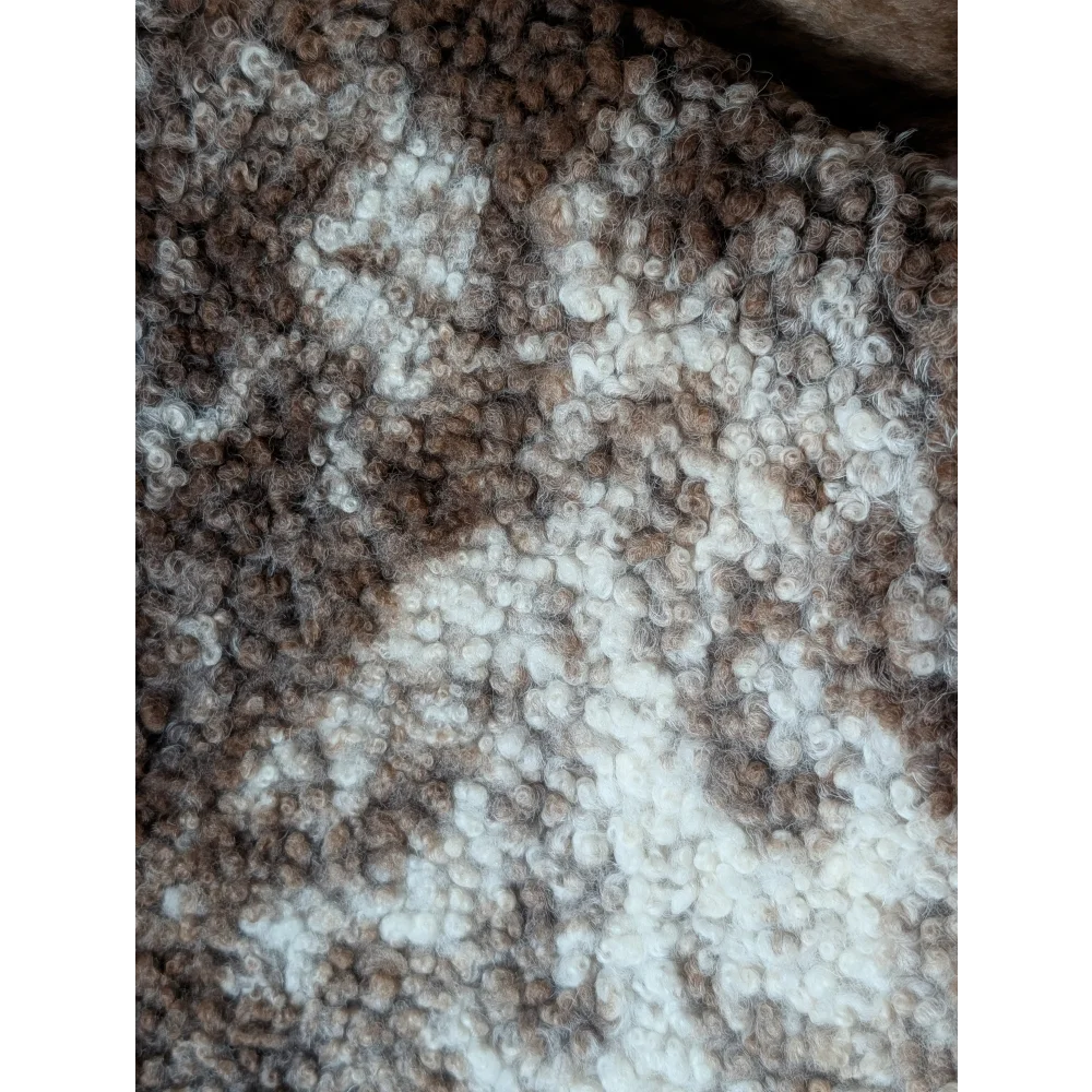 A cozy tibet highland spotted sheepskin with soft brown and white curly fibers perfect for home decor
