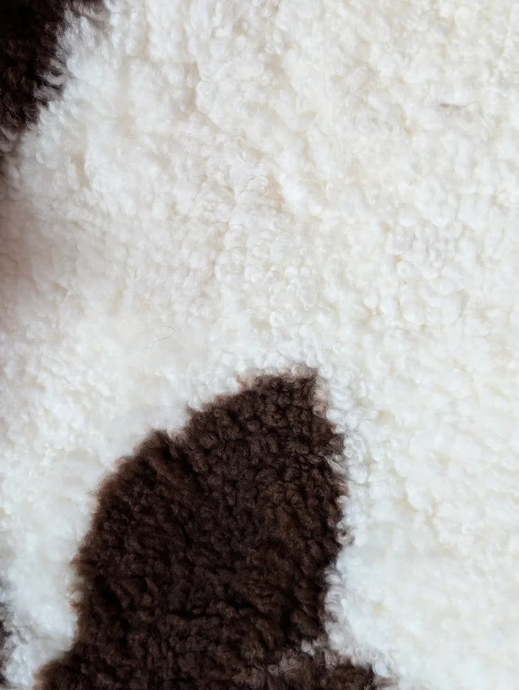 White and brown fluffy tibet highland spotted sheepskin with plush textured surface in size 41.5 by 25.5 inches